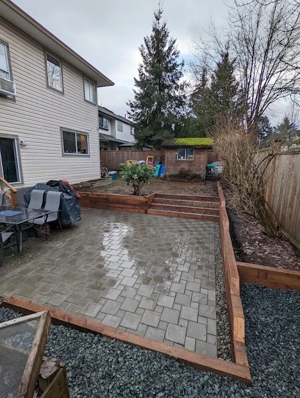 Wide paver patio spanning the full yard